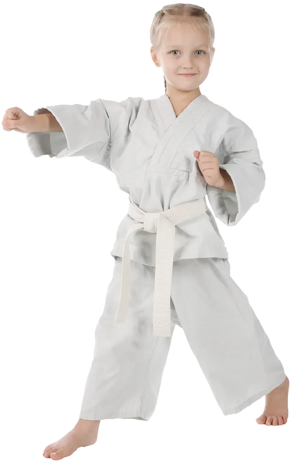 A young girl in a white karate uniform is standing in a karate pose.