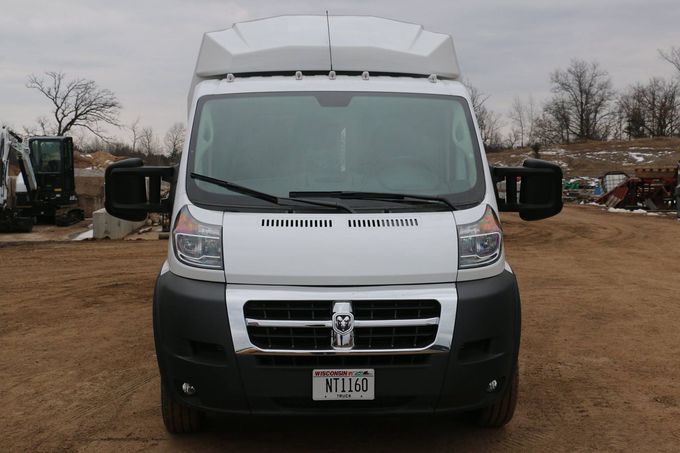 White Dodge ProMaster van with a black bumper, parked outside.