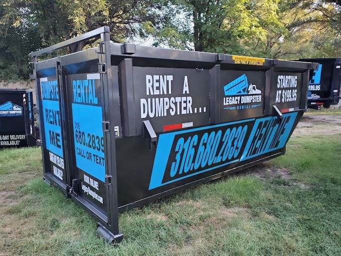 A dumpster is sitting on top of a lush green field.