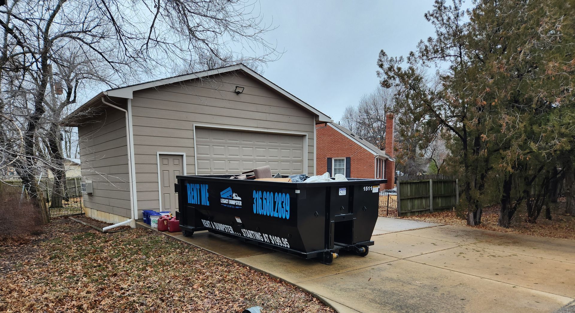 A dumpster is parked in front of a house.