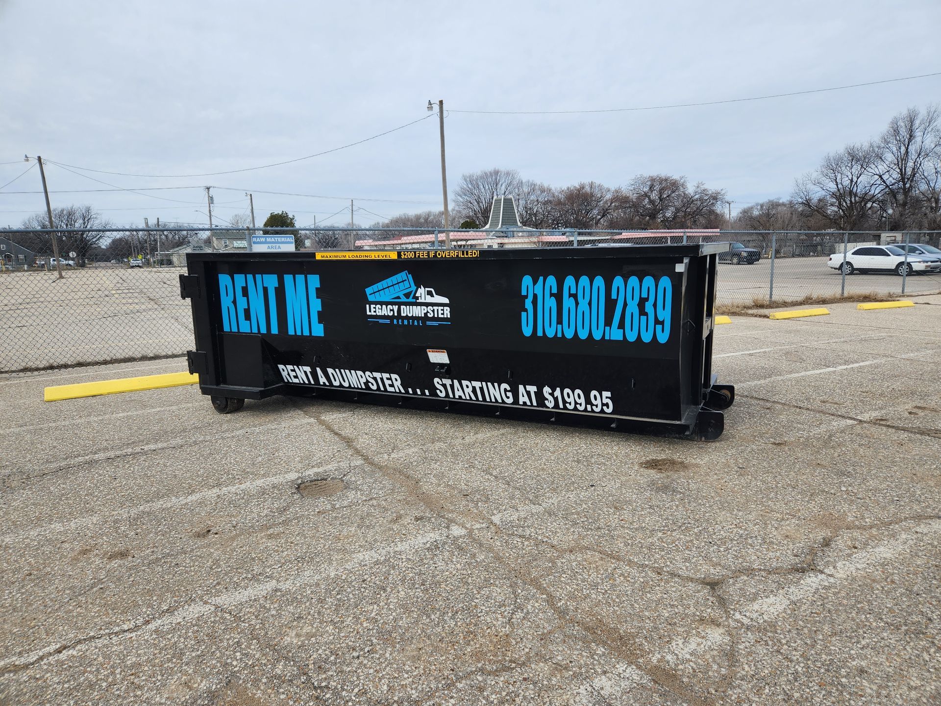 A dumpster is sitting in a parking lot.