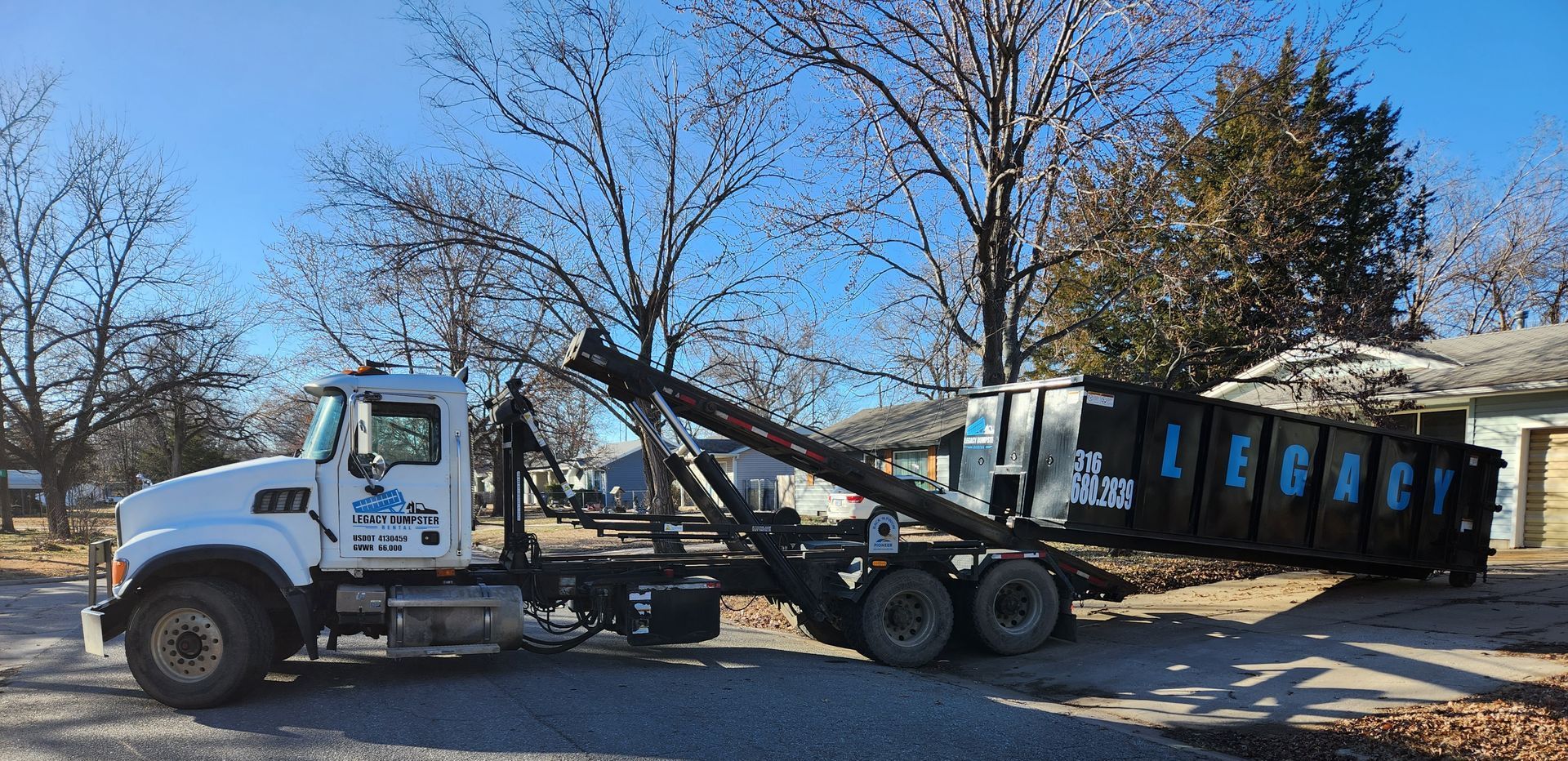 A dump truck is parked in a driveway next to a house.