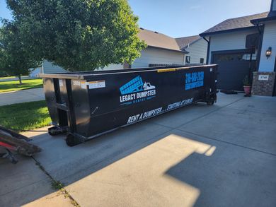 A 20 yard dumpster is parked in front of a house in wichita, KS.