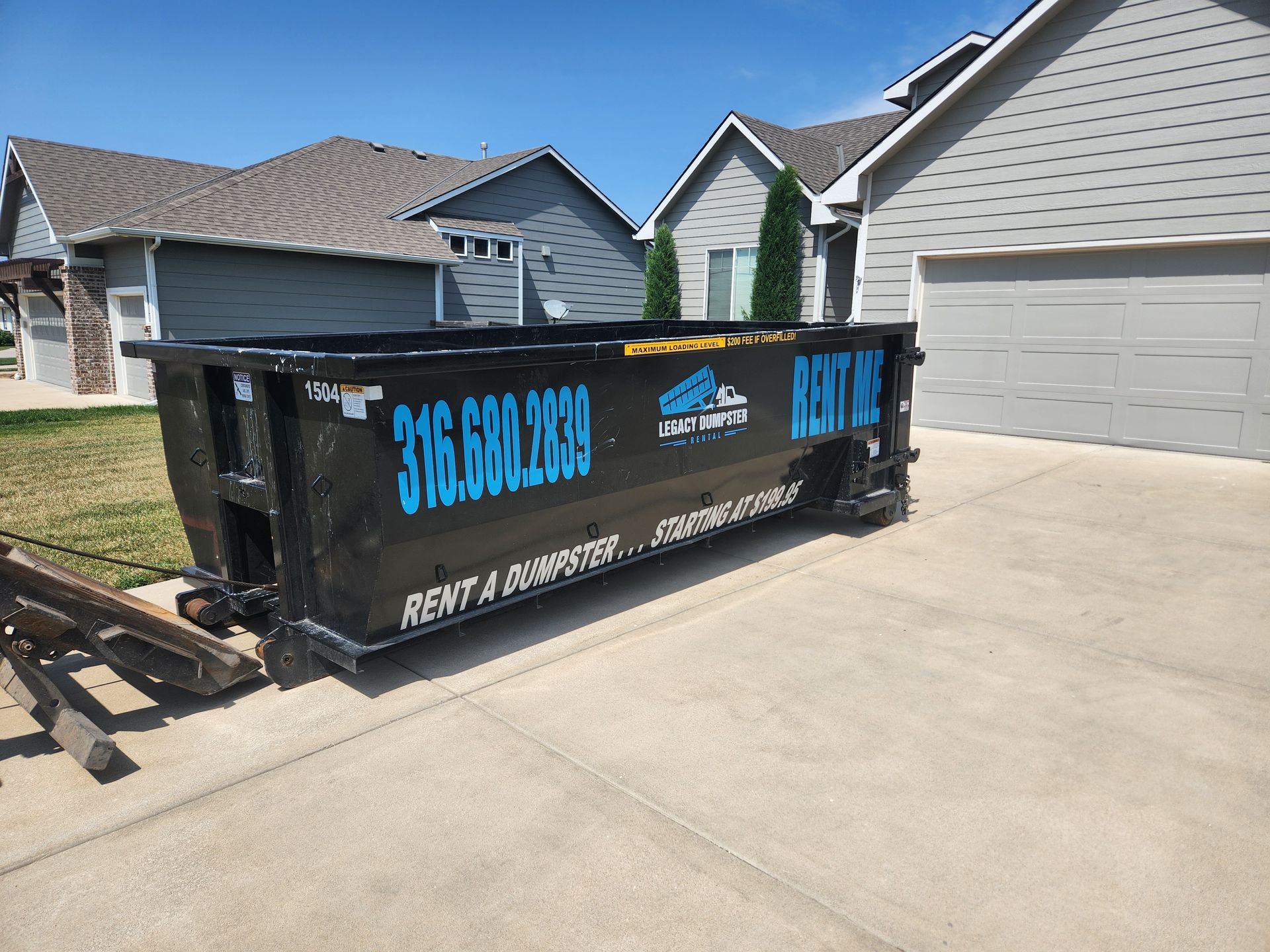 A dumpster is parked in front of a house.