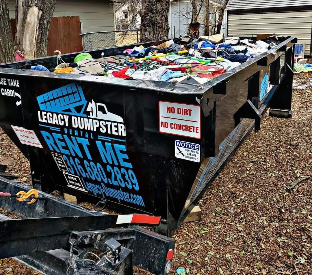 A dumpster is filled with trash and is on a trailer.