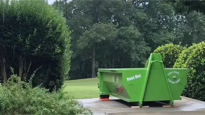 A green 15 yard dumpster is sitting in front of a black 15 yard dumpster wichita