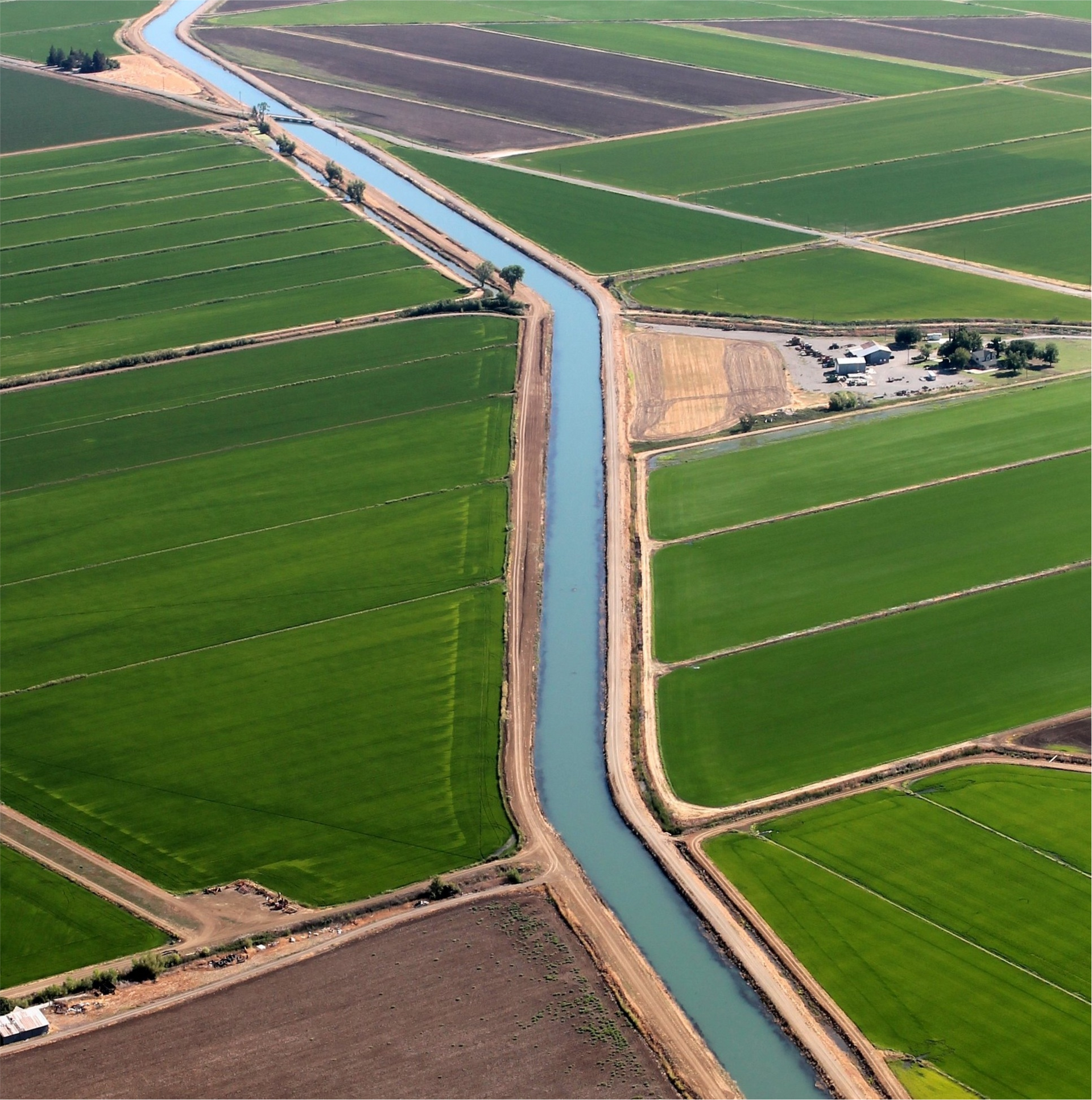 An aerial view of a river running through a lush green field