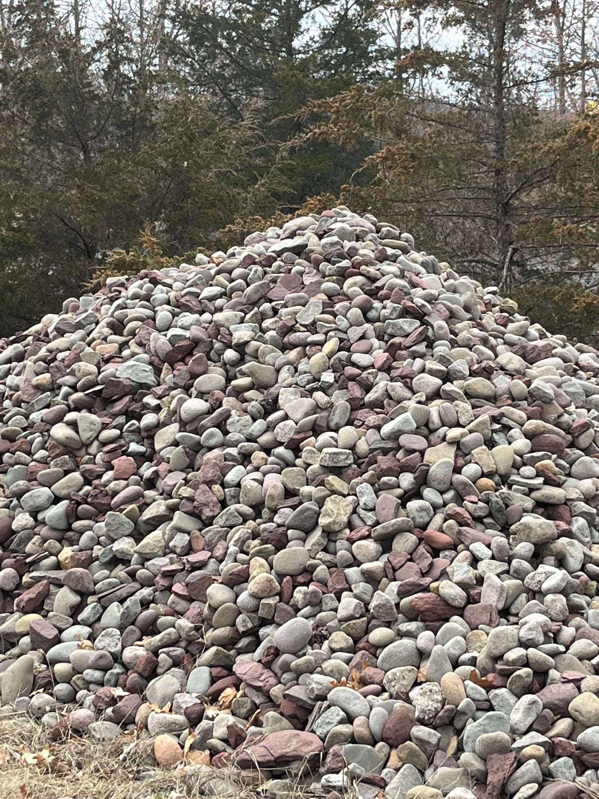 A pile of rocks is sitting on top of a dirt field.