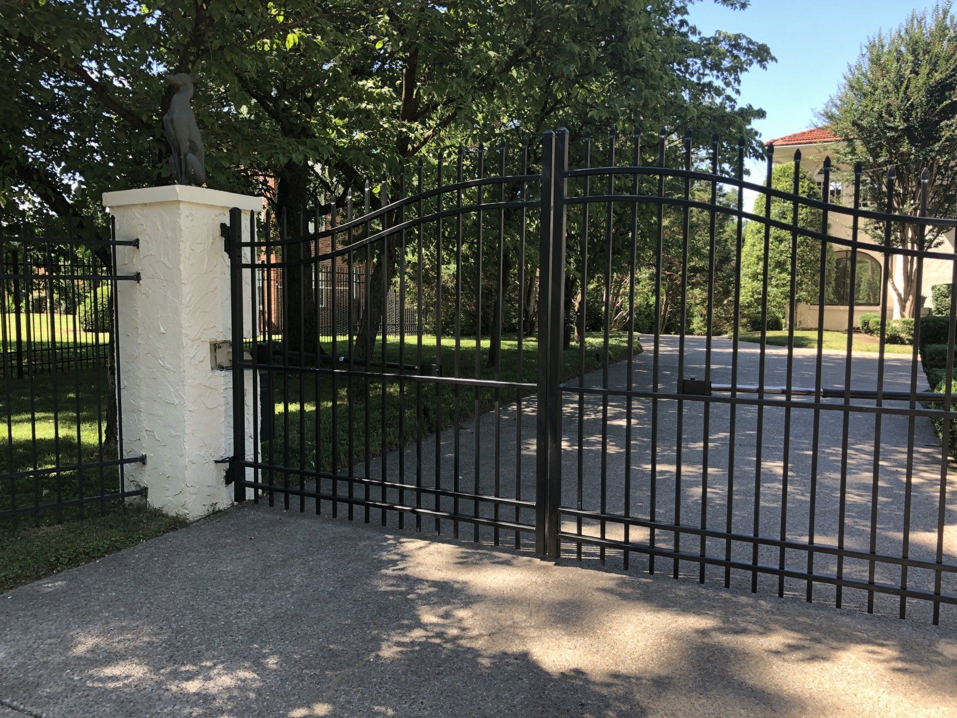 residential North Tampa property featuring an automatic driveway gate with a matching black steel perimeter fence