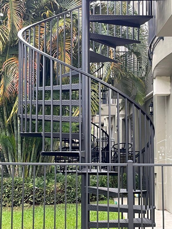 black circular stairs installed behind a townhome for easy access to 2nd story
