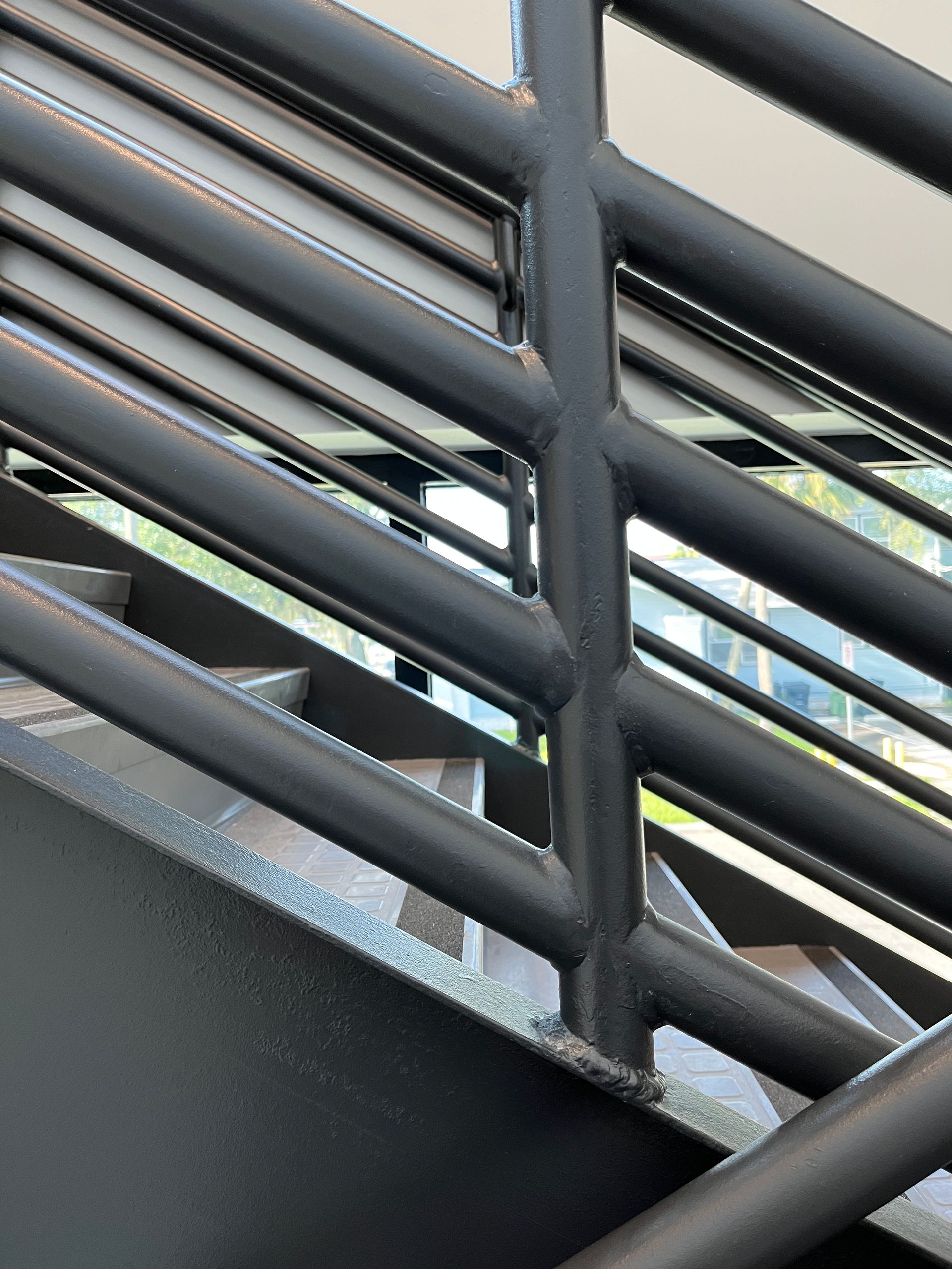 Closeup of painted steel stair handrails in a business stairwell