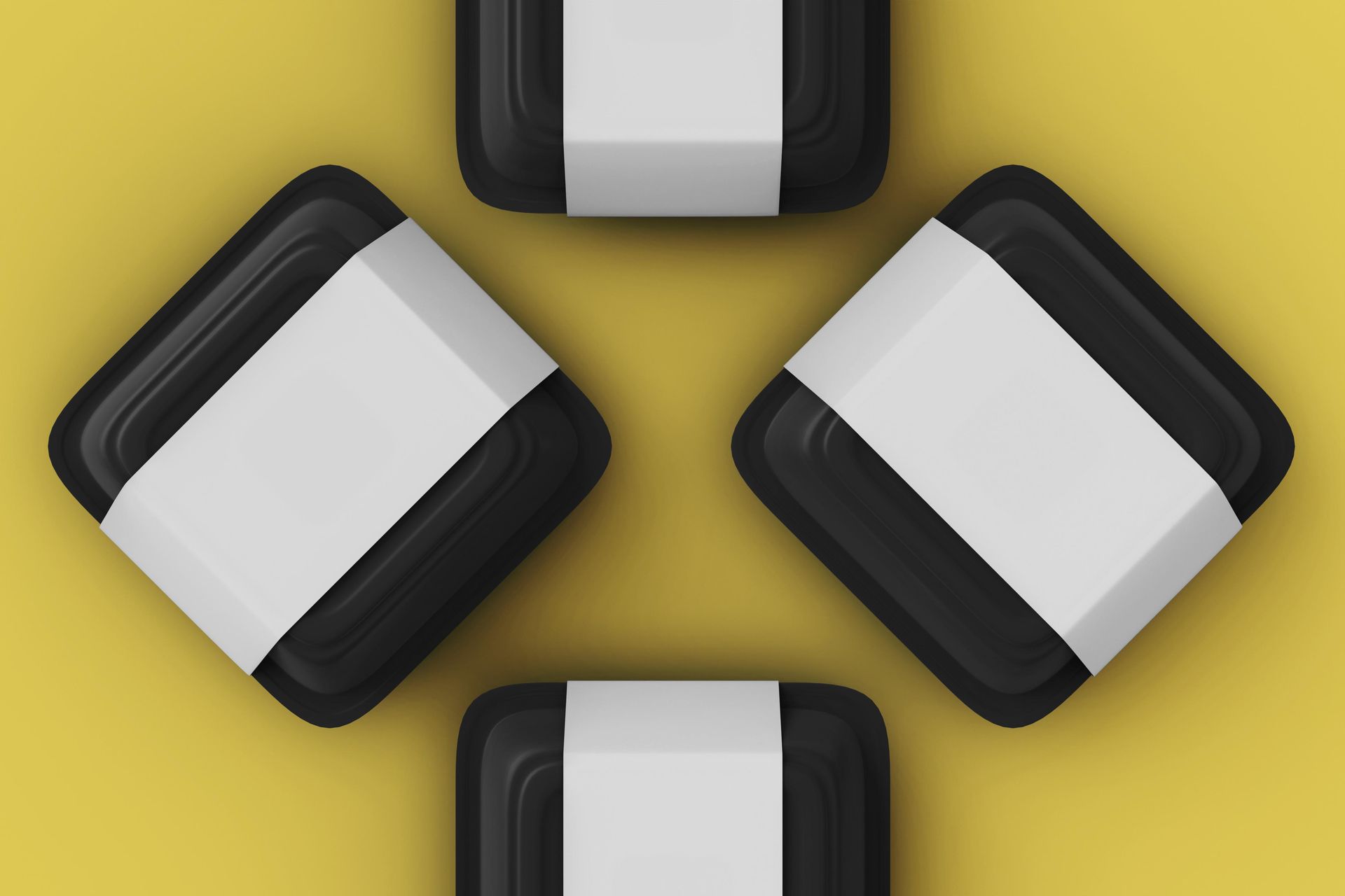 Four black containers with white labels on a yellow background.