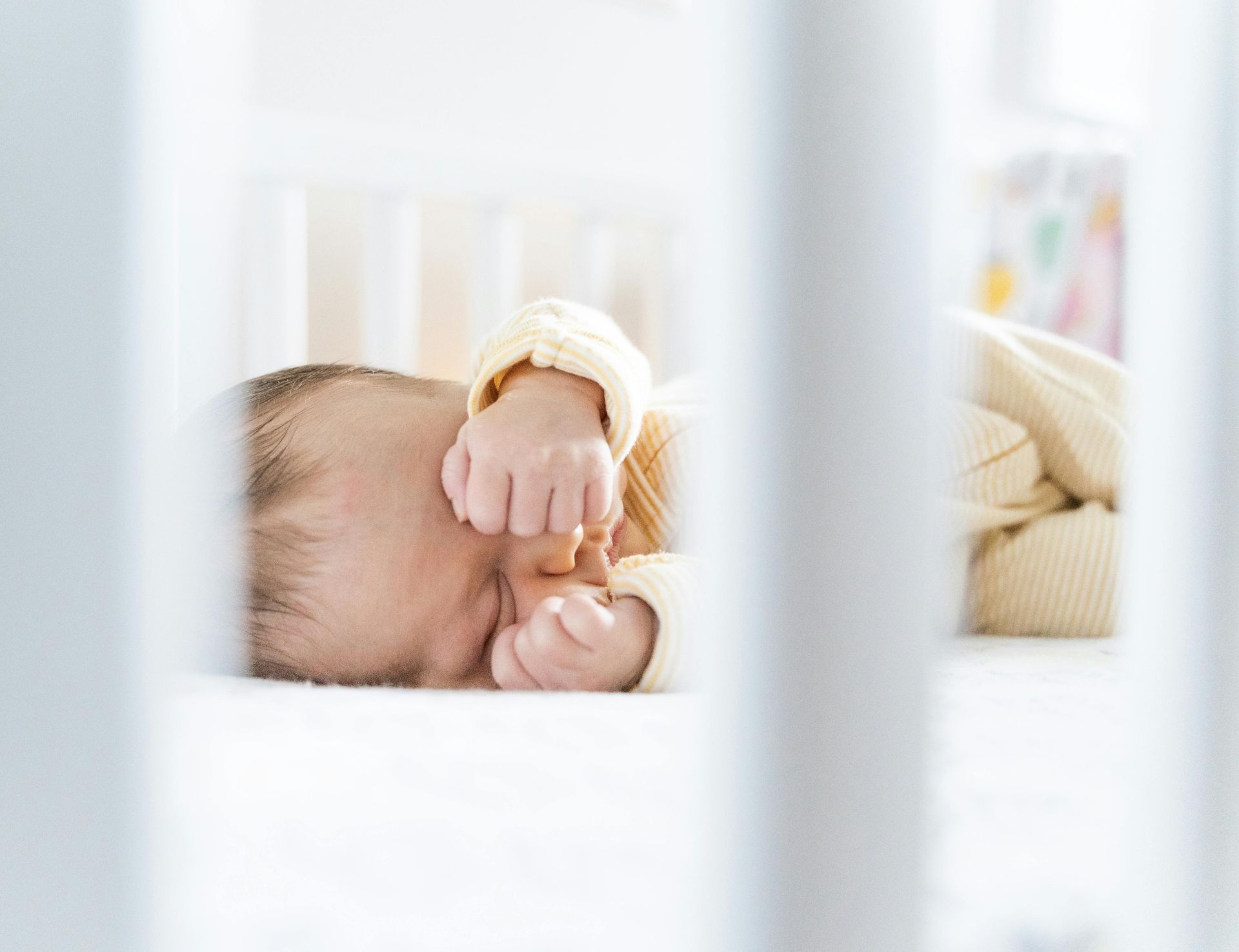 Baby sleeping peacefully in a crib while adjusting to daylight savings time with gentle support