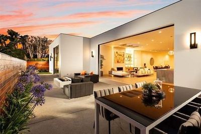 A patio with a table and chairs in front of a house.