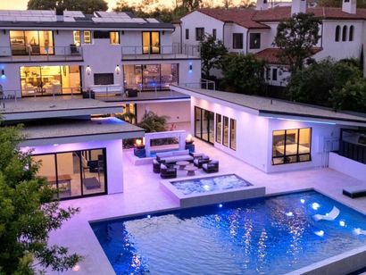 A large house with a large swimming pool in front of it