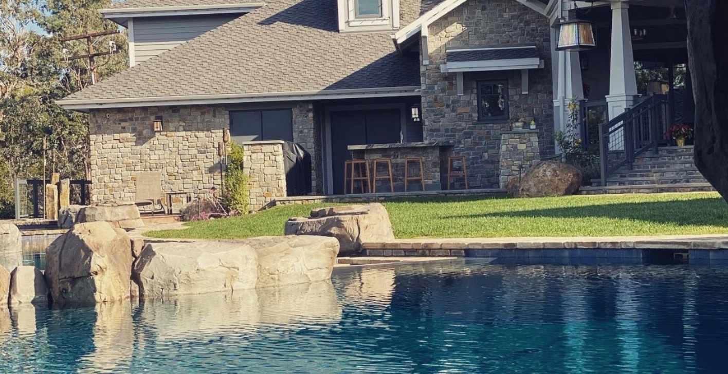 A large house with a swimming pool in front of it.
