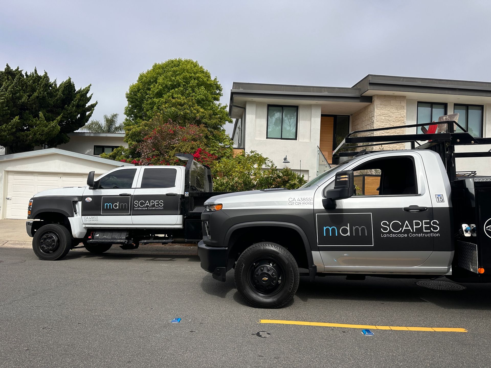 Two trucks are parked in front of a house.