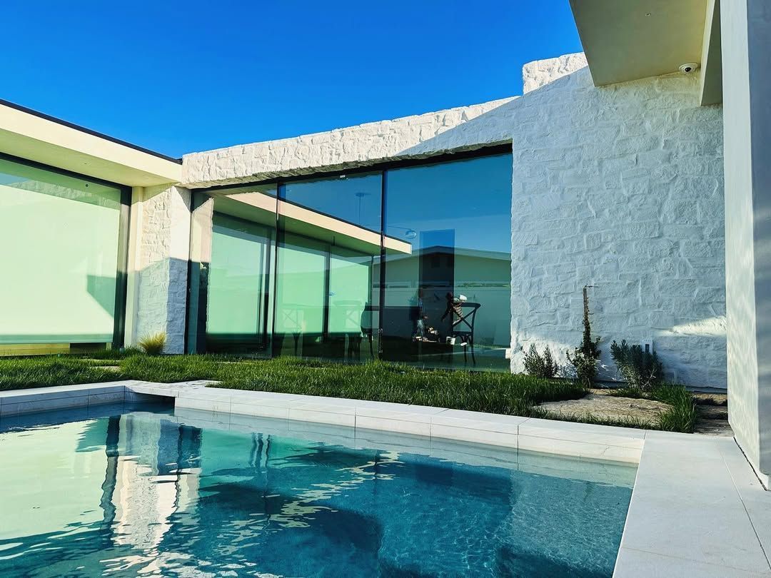 A large house with a swimming pool in front of it.