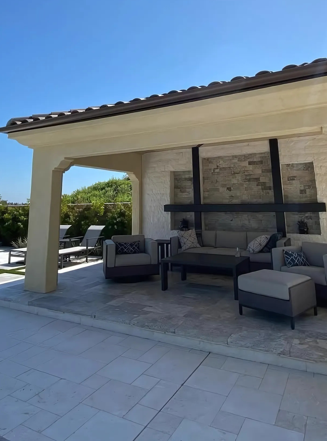A large swimming pool with a waterfall and a fire pit