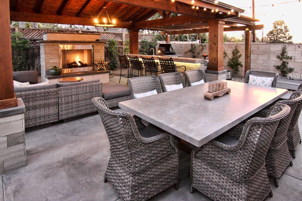 A patio with a table and chairs and a fireplace.