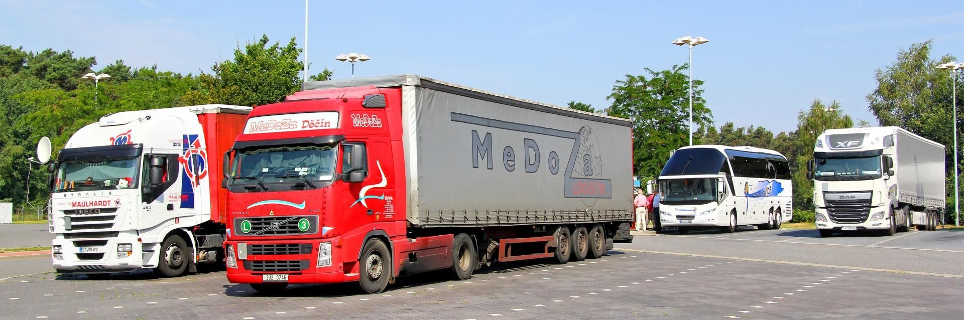 Red and white trucks parked in a lot on a sunny day