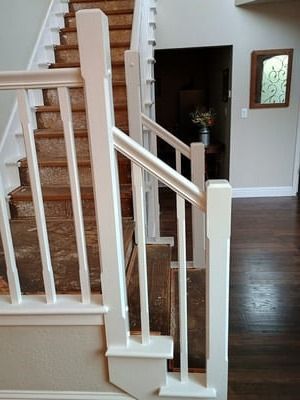 White stair railing beside carpeted wooden stairs in a home interior