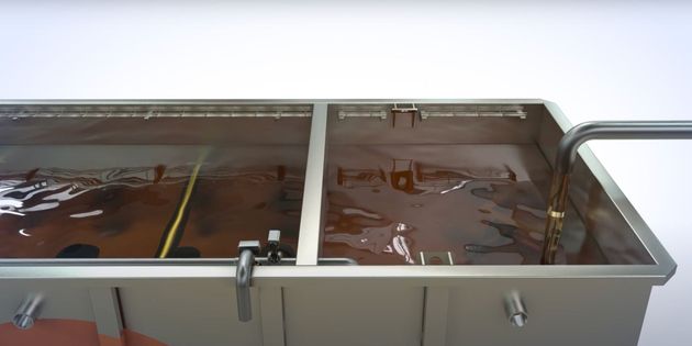 A large stainless steel tank filled with brown liquid.