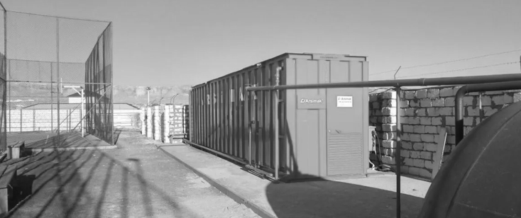 A row of blue containers are sitting next to each other in a parking lot.
