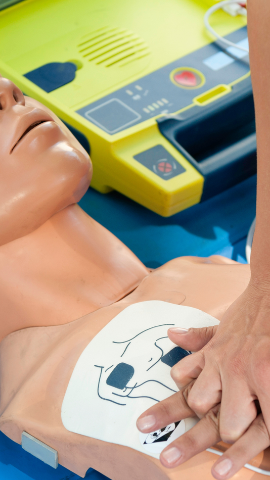 Manichino per addestramento alla rianimazione cardiopolmonare (RCP) con elettrodi del defibrillatore automatico esterno (DAE) posizionati sul torace.