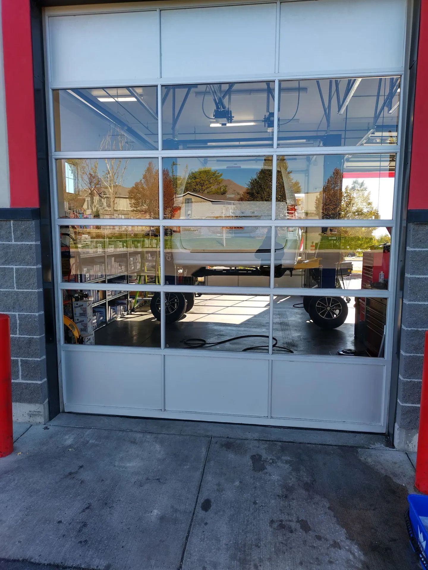 A car is parked in a garage with a glass door.