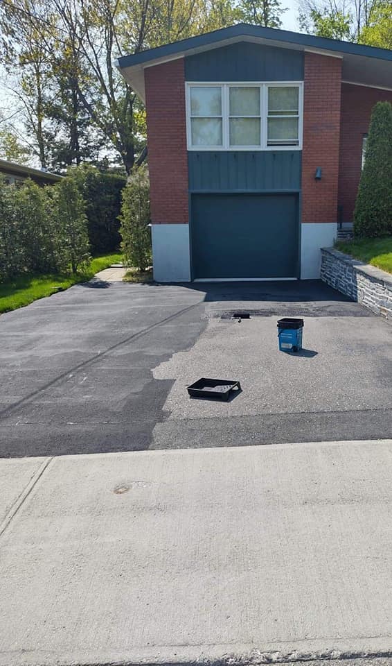 Allée en cours de goudronnage ; l’allée foncée contraste avec le trottoir clair. 