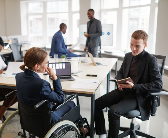 A woman in a wheelchair is sitting at a table with a man.