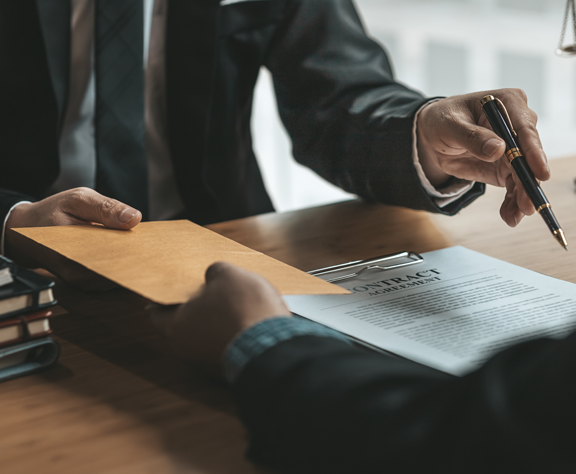 A man in a suit and tie is handing a piece of paper to another man.