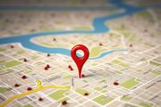 Red location pin on a city map with roads and a river