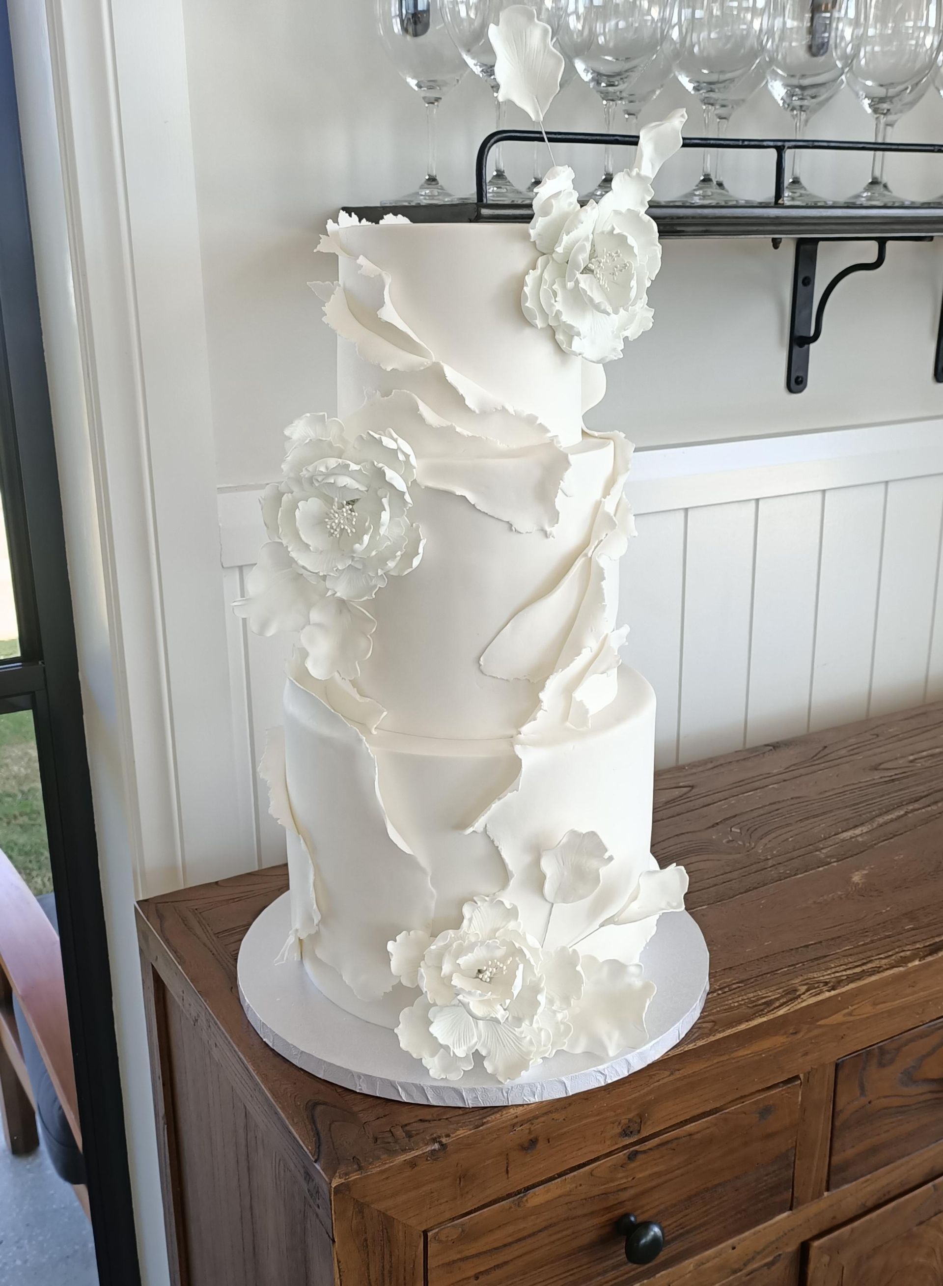 Three tier white fondant wedding cake with delicate ruffles and sugar flowers Gold Coast