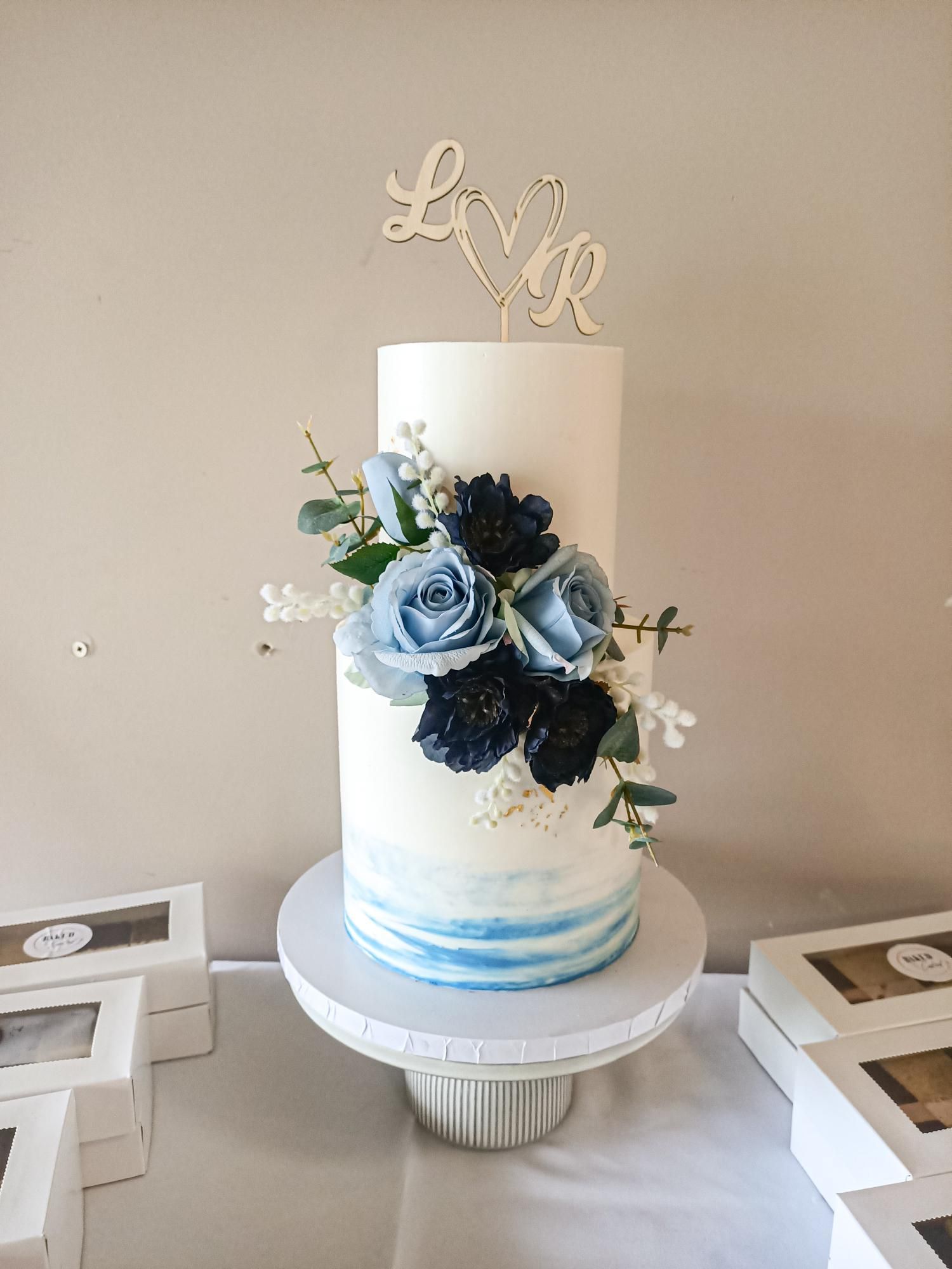 Blue and white tiered wedding cake with flowersGold Coast
