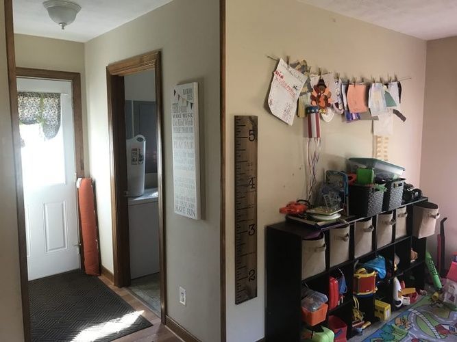 A room with a lot of toys and a ruler on the wall.