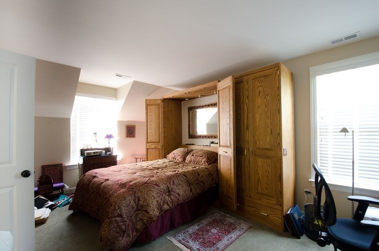 A bedroom with a bed and a desk in it