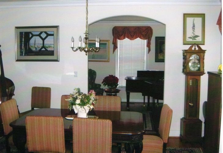 A dining room with a table and chairs and a grandfather clock
