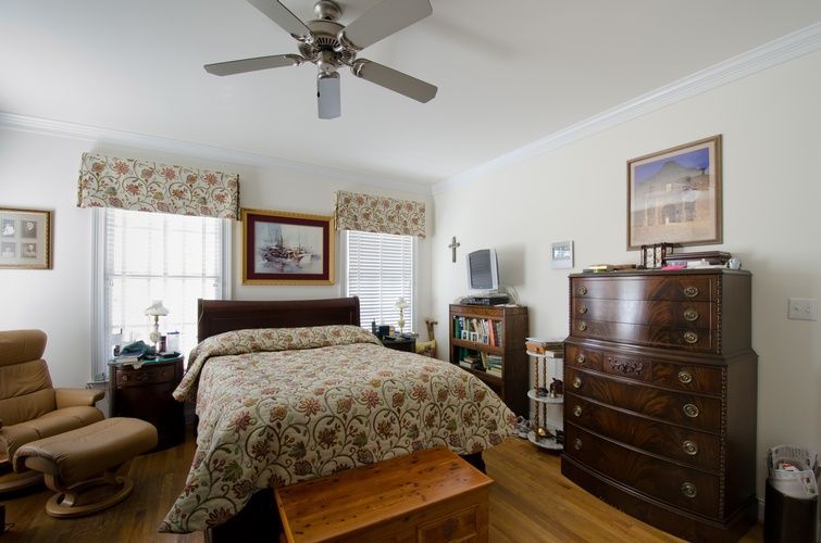 A bedroom with a large bed and a ceiling fan