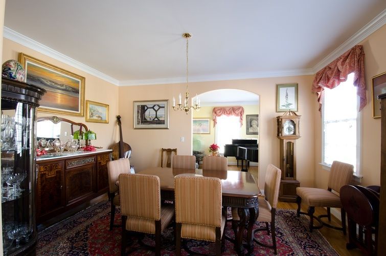 A dining room with a table and chairs and a grandfather clock