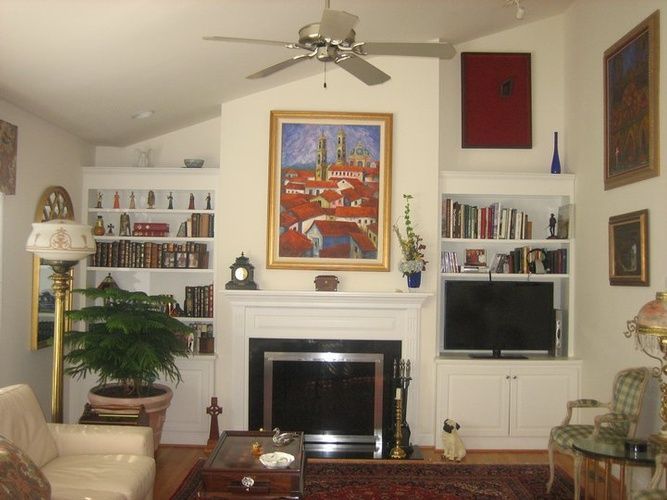 A living room with a fireplace and a ceiling fan