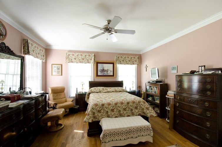 A bedroom with a large bed and a ceiling fan