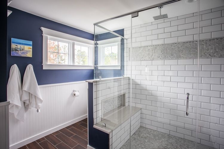 A bathroom with a walk in shower and a window.