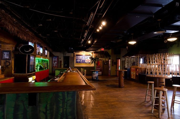 A large room with a bar and tables in it.