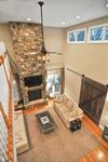 An aerial view of a living room with a fireplace and a ceiling fan.