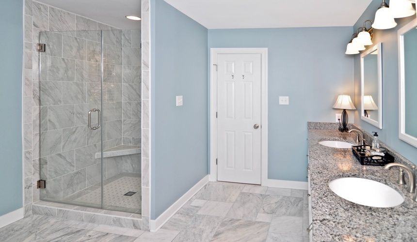 A bathroom with two sinks and a walk in shower