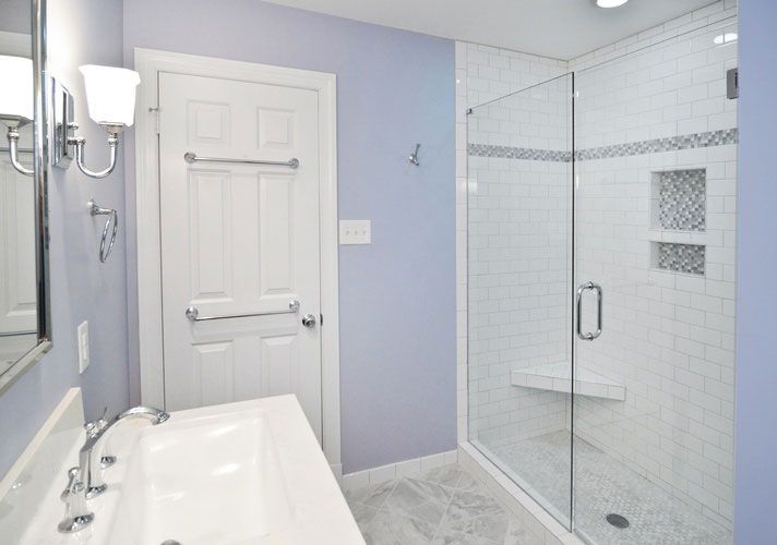 A bathroom with a walk in shower and a sink
