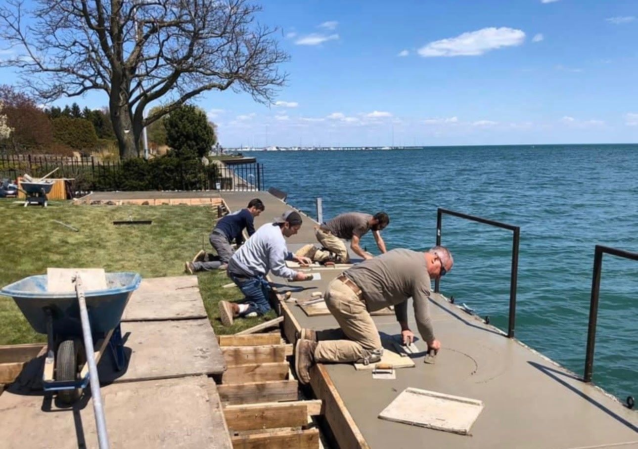 A concrete driveway is being built in front of a house