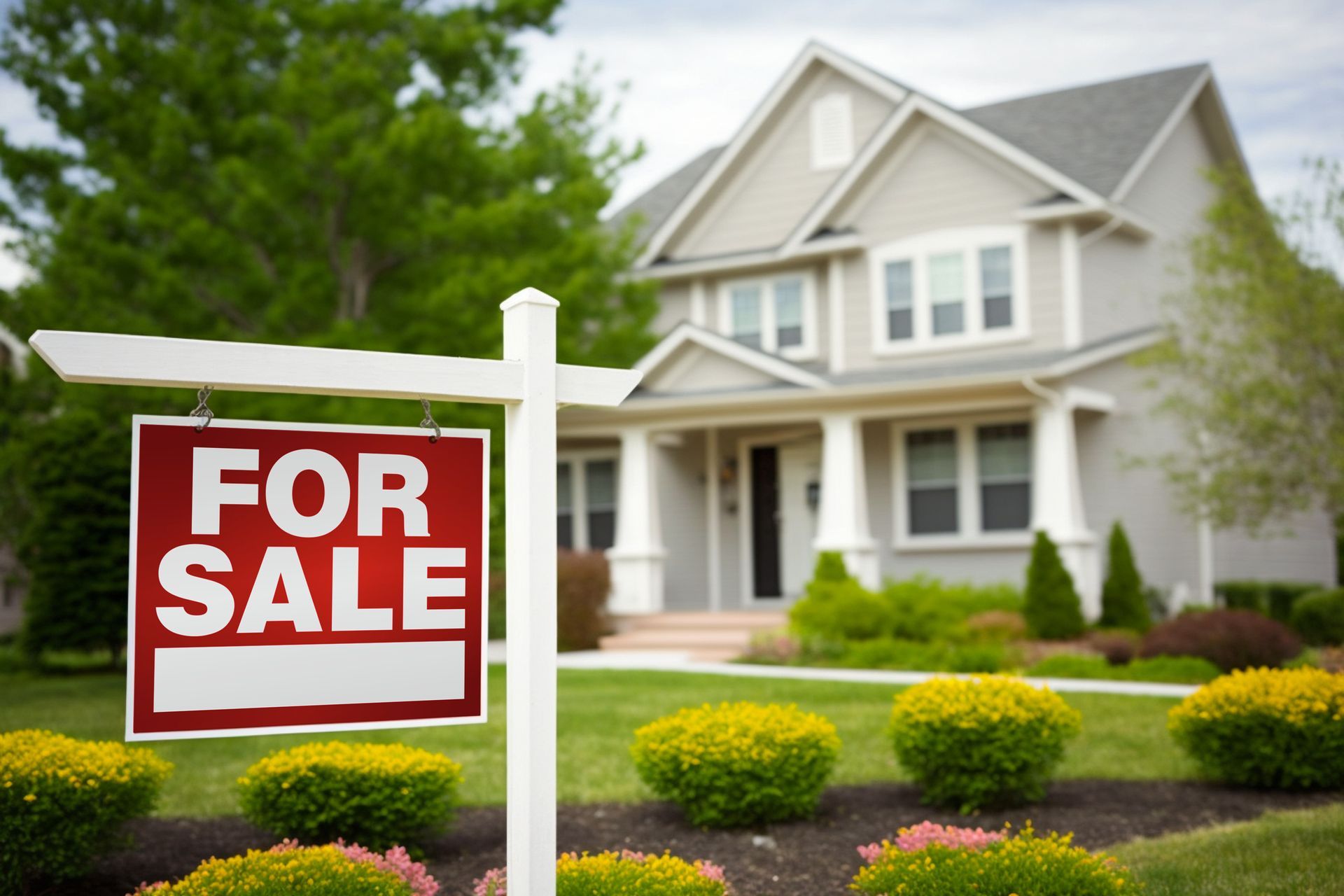 Houses for sale sign in front of a suburban home with a landscaped yard. For Sale sign in front of a suburban house with a landscaped yard